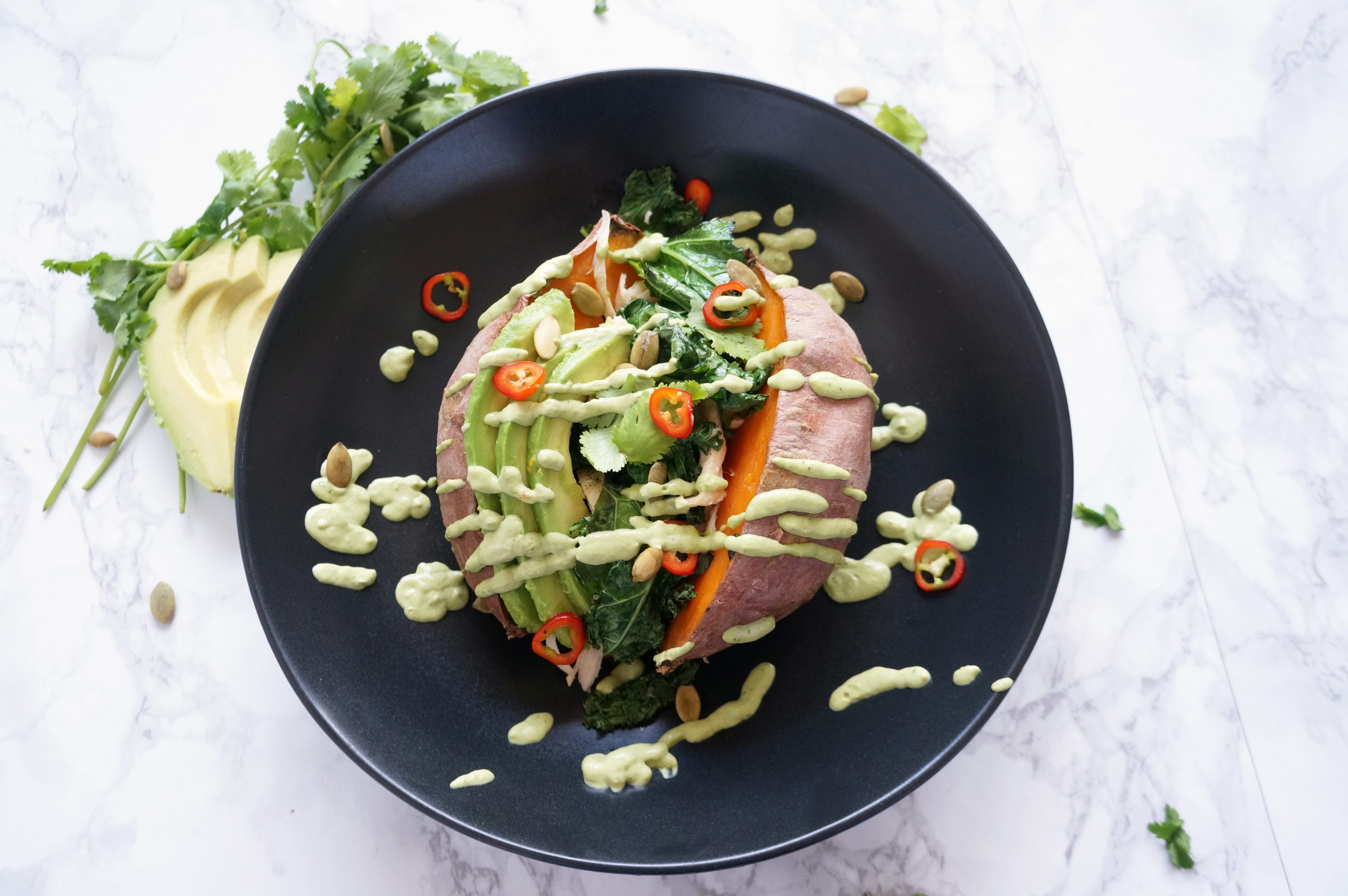 Loaded Sweet Potato with cilantro lime sauce, kale, chicken, avocado