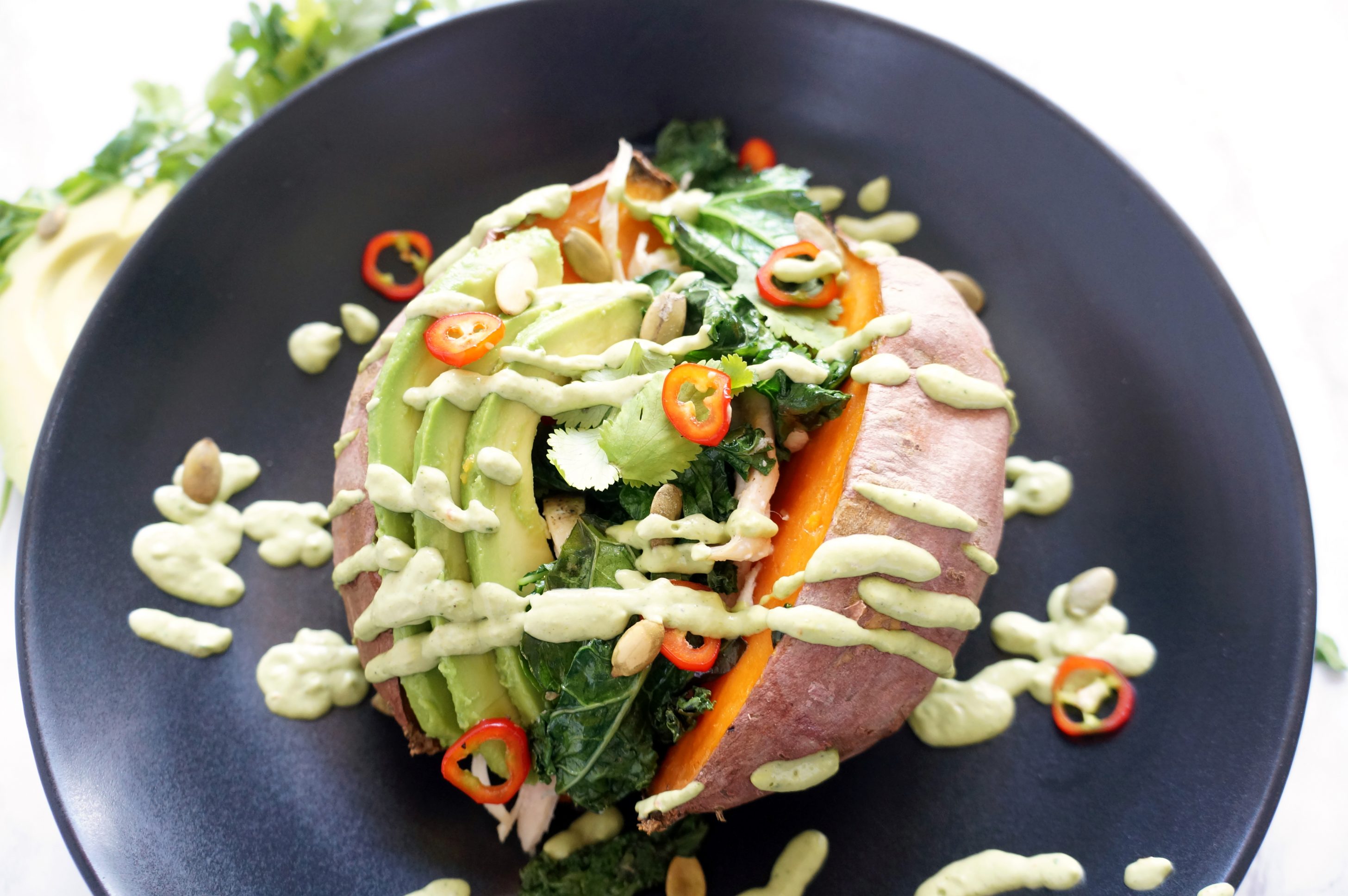 Loaded Sweet Potato with cilantro lime sauce, kale, chicken, avocado