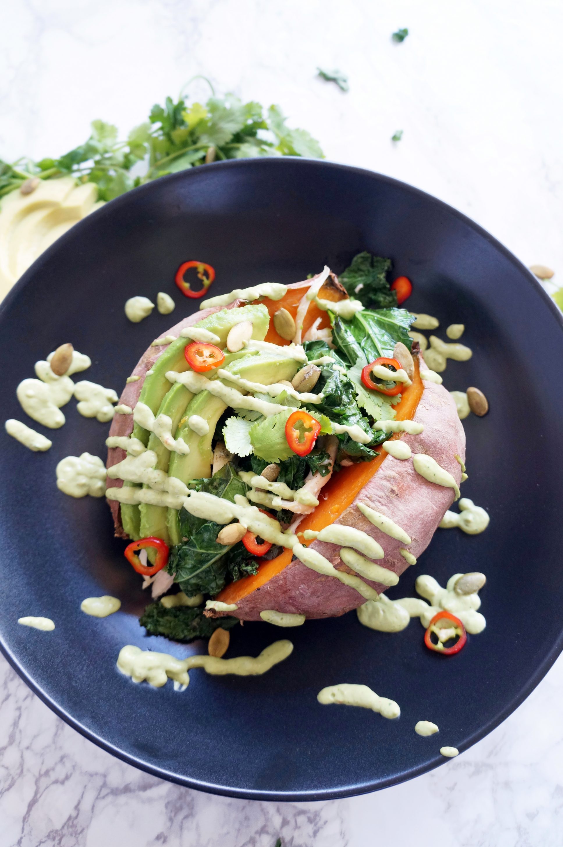 Loaded Sweet Potato with cilantro lime sauce, kale, chicken, avocado