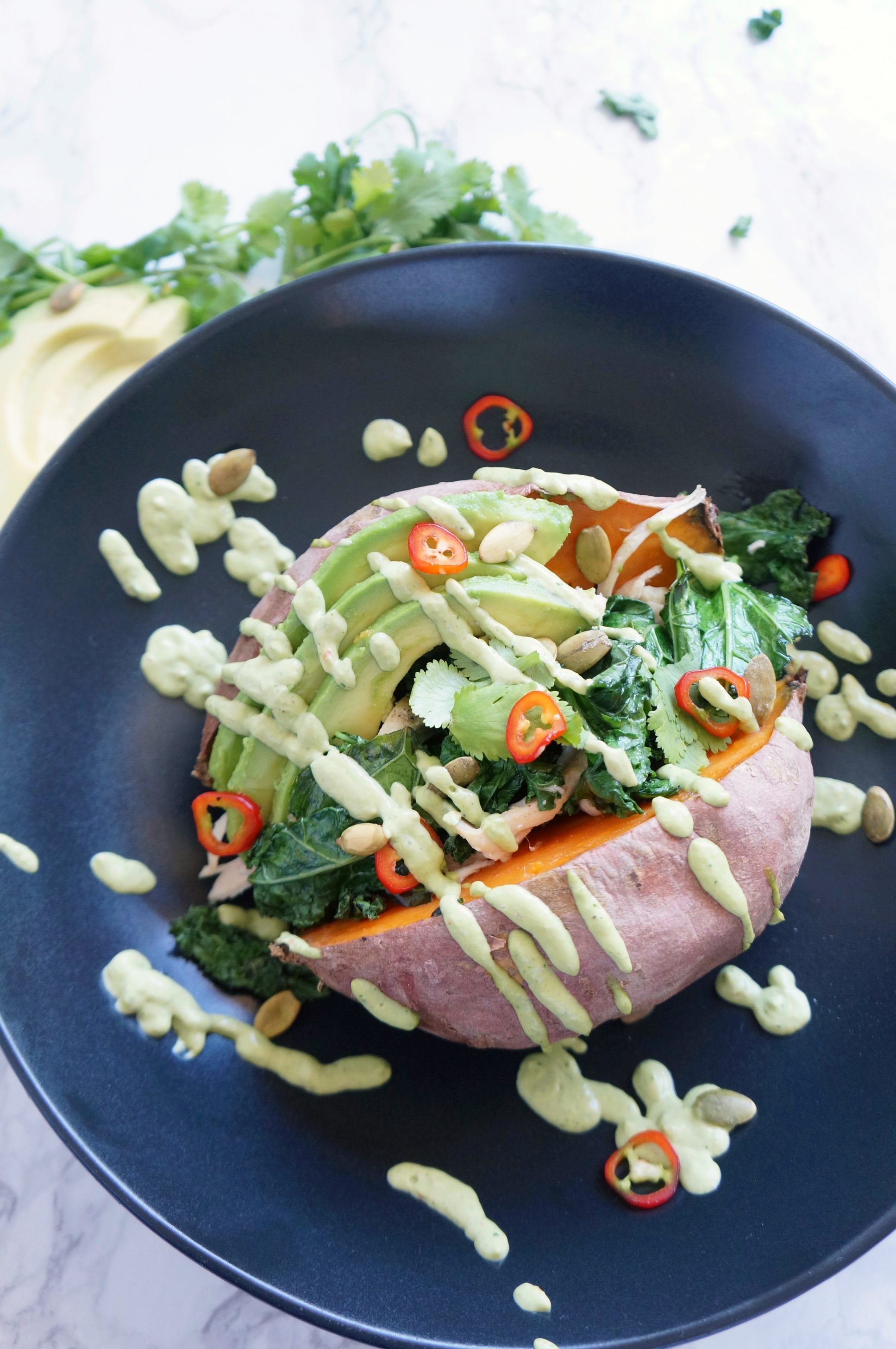 Loaded Sweet Potato with cilantro lime sauce, kale, chicken, avocado