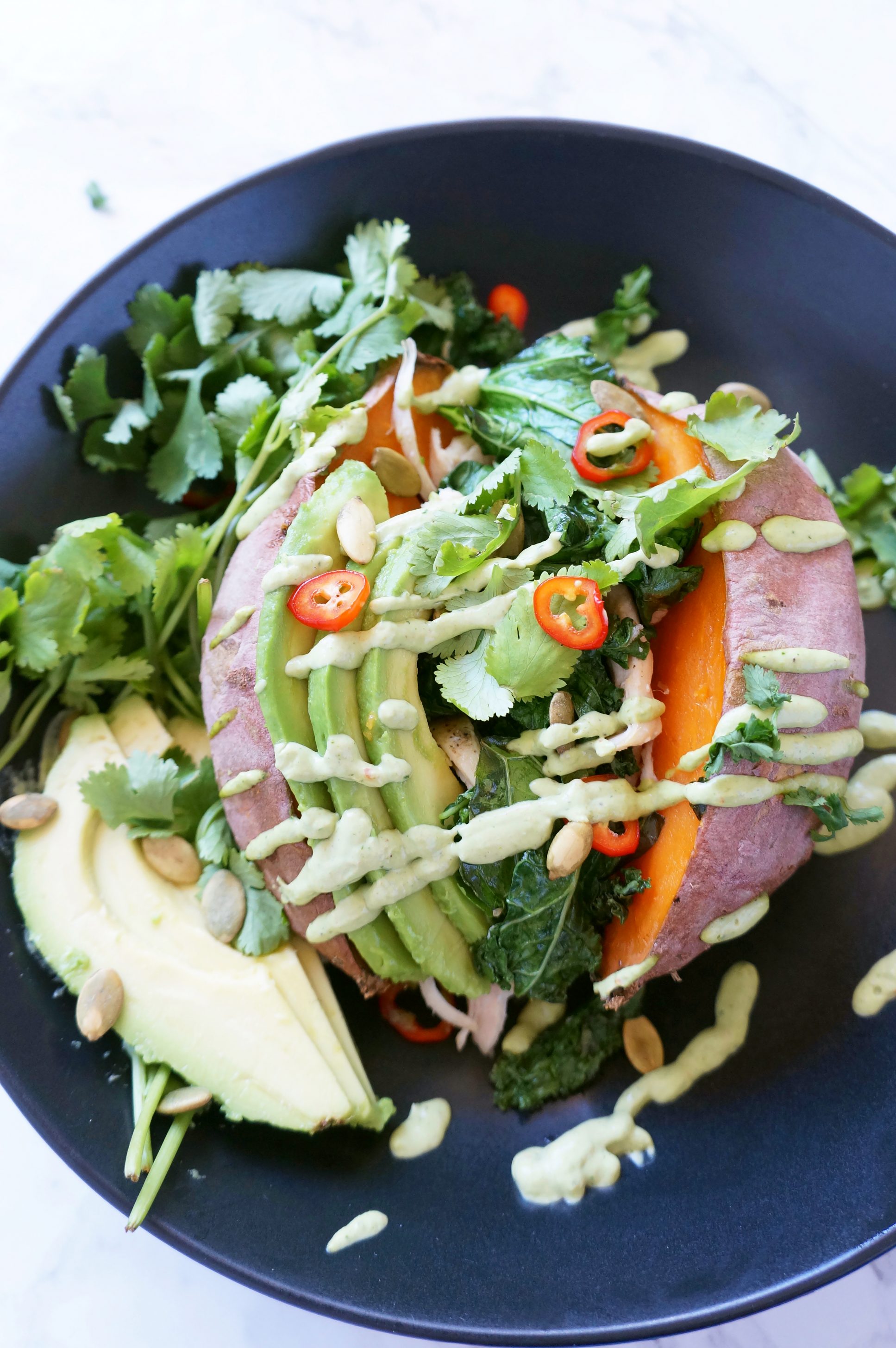 Loaded Sweet Potato with cilantro lime sauce, kale, chicken, avocado