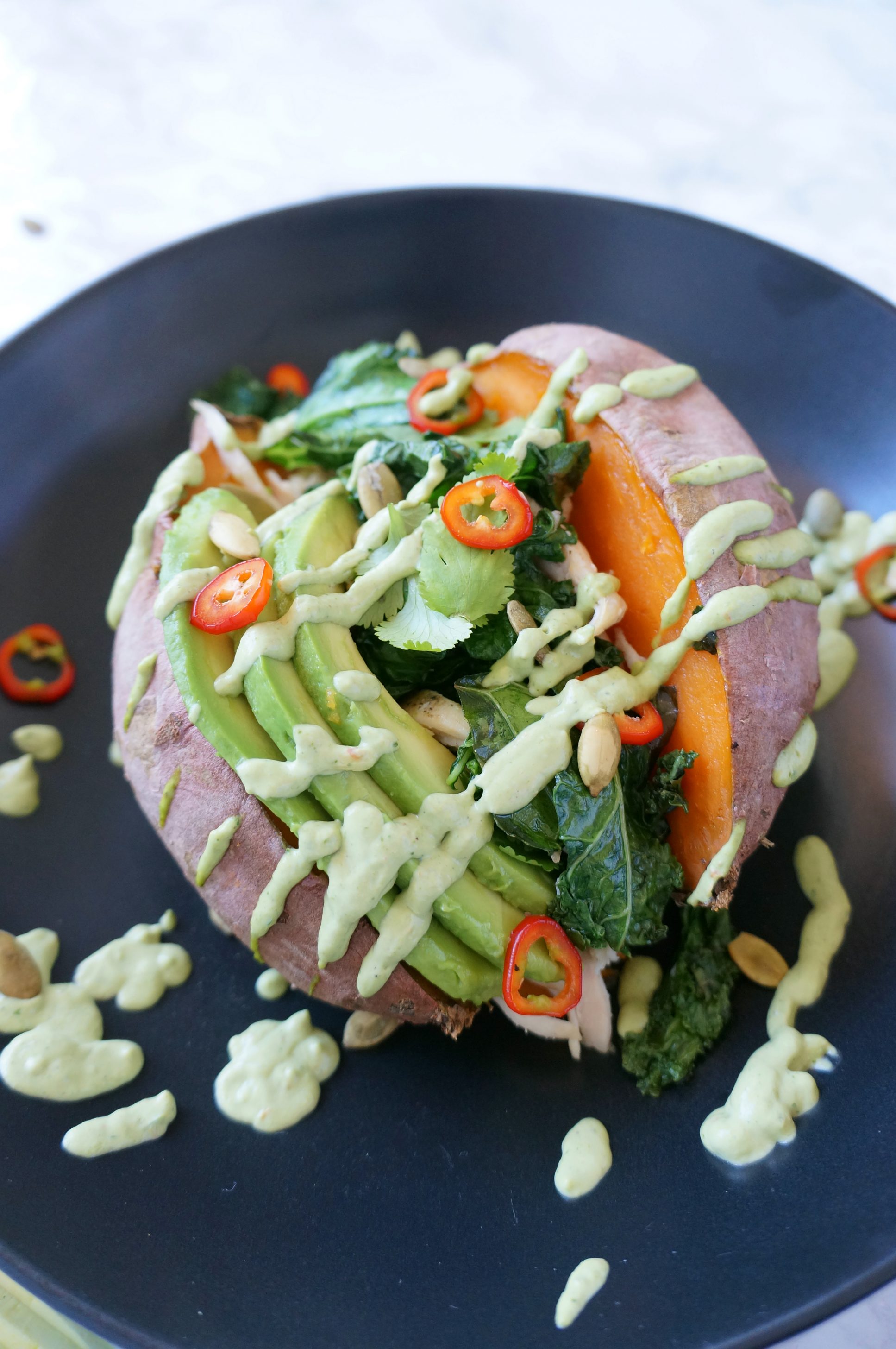 Loaded Sweet Potato with cilantro lime sauce, kale, chicken, avocado