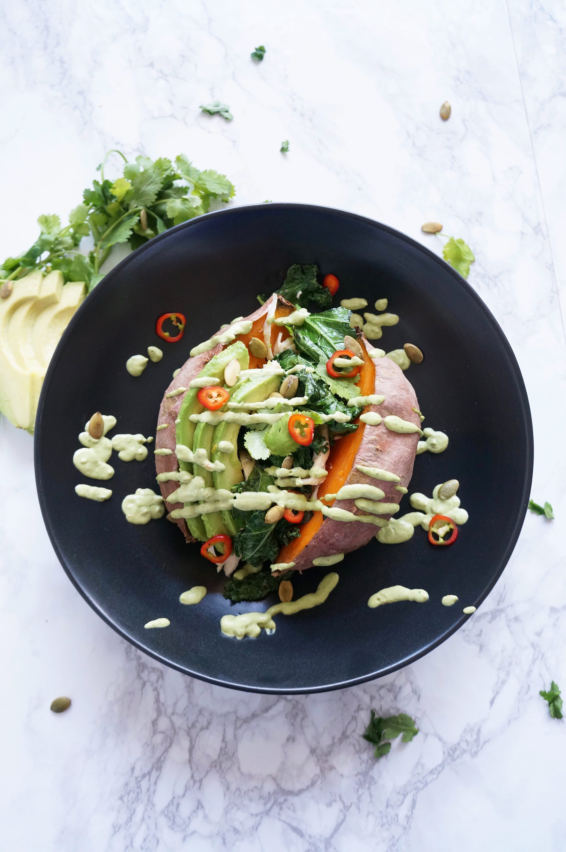 Loaded Sweet Potato with cilantro lime sauce, kale, chicken, avocado